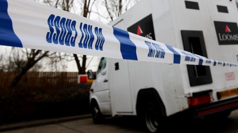 This file photo shows police incident tape around a Loomis security van in London
