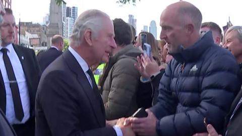 King Charles speaks to a man queueing near Lambeth Bridge
