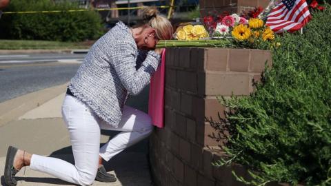 Lynne Griffin pays her respects at a makeshift memorial near the Capital Gazette where five people were shot and killed by a gunman.