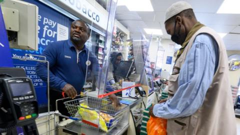 Staff and customer at Tesco store