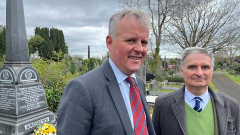 Two descendants of Professor Thomas Andrews pictured at his grave.