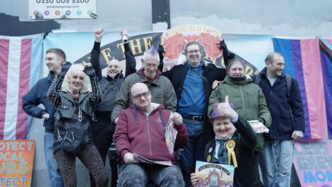 Black Cap campaigners stand outside the pub cheering