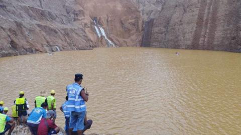 Rescue workers trying to locate the missing miners swept into the lake after a landslide on Sunday