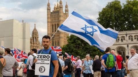 A man with an Israeli flag on Parliament square in London