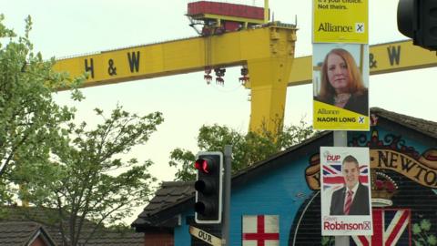 Election posters on a lamppost in the shadow of the Harland and Wolff cranes