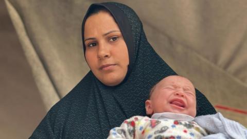 Zouahra holds baby Mohammed