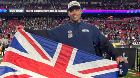 Aden Durde holding a British flag after winning Super Bowl 60