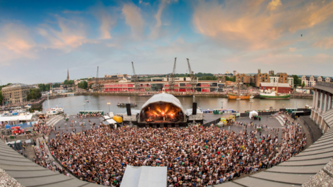 The Bristol Sounds stage at the harbourside in the city, with thousands of people in a large crowd facing the stage