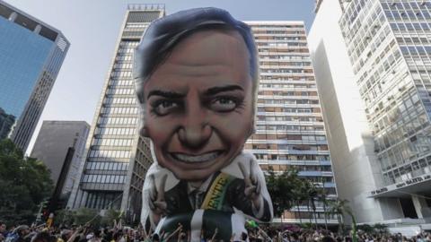 Supporters of far-right presidential candidate Jair Bolsonaro install a giant inflatable doll with the image of the politician during an act to show their support