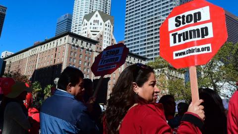 Anti-Trump protesters hold signs in Los Angeles, a sanctuary city.