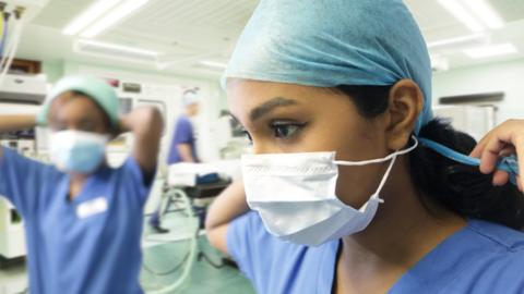 Medical professionals putting on PPE