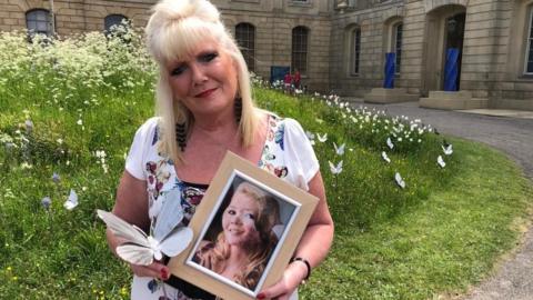 Mother Tracy Hollow-chuck holding a picture of her daughter Kimberley