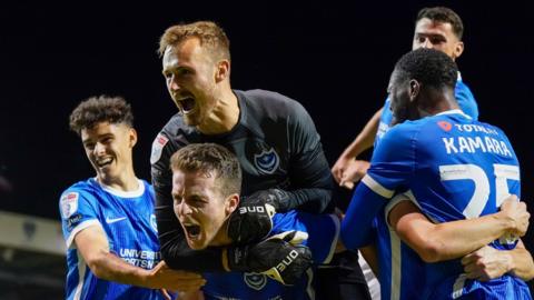 Portsmouth players celebrate their injury time winner over Wycombe in League One.