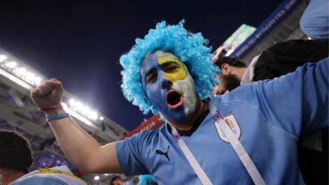 A Uruguay fan celebrates victory over Portugal in their last 16 game at the World Cup