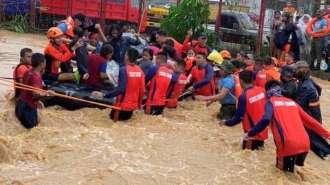 Philippine Coast Guard personnel rescue stranded residents from floods in Cagayan De Oro City, Philippines. Photo: 16 December 2021