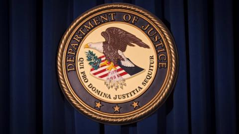 The Department of Justice (DOJ) official seal / emblem / logo is pictured on a wall in New York, United States