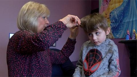 Kathy giving boy hair cut