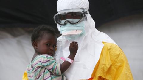 A man in a protective suit holding a child