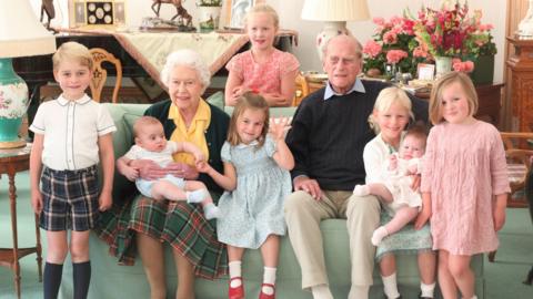 Undated handout image released on 14/04/21 of Queen Elizabeth II and the Duke of Edinburgh with their great grandchildren. Pictured (left to right) Prince George, Prince Louis being held by Queen Elizabeth II, Savannah Phillips (standing at rear), Princess Charlotte, the Duke of Edinburgh, Isla Phillips holding Lena Tindall, and Mia Tindall.