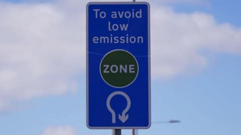A sign on the road shows you must turn around at a roundabout to avoid the charge