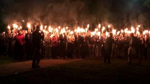 The group lit torches in a move that the mayor said was 'designed to instill fear in our minority populations'