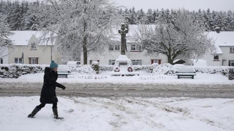 A woman walking through the snow in Braco, near Dunblane in Scotland