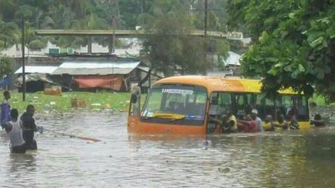 Zanzibaris pulling a bus stuck following flooding on the islands of Zanzibar