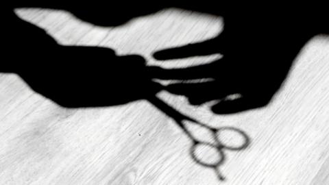 Shadow of barber holding scissors