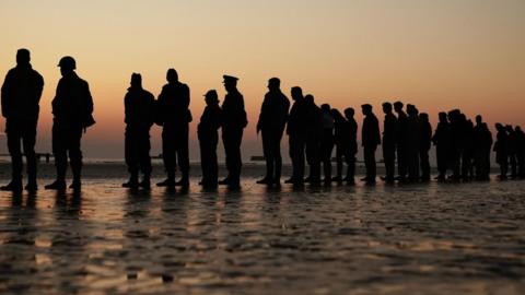 People on Gold Beach at sun rise