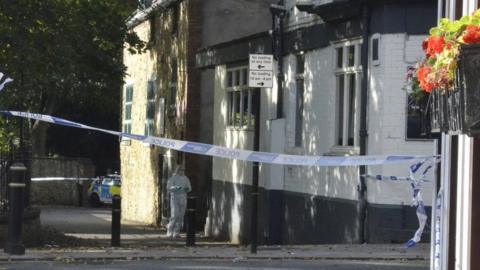 A forensics officer outside the pub