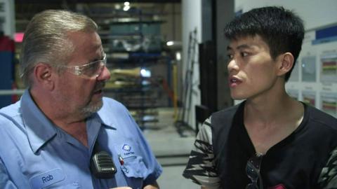 A US and Chinese worker in a scene from American Factory