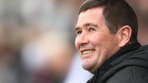 Mansfield Town boss Nigel Clough smiles in the dugout