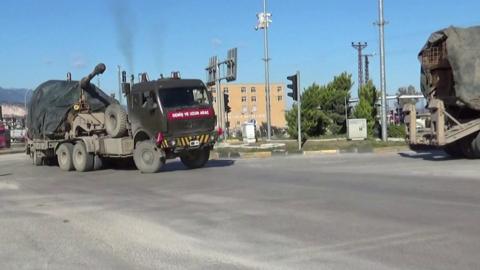 Turkish military vehicles pass through Kirikhan on the way to Syria