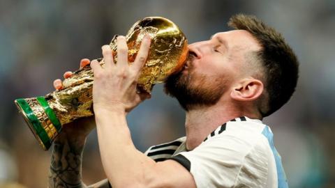 Lionel Messi celebrates with the World Cup