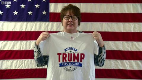 Woman holds up "Michigan Trump Republicans" shirt