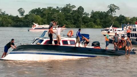 Rescuers help passengers on board a ferry that capsized at Tanjung Selor, North Kalimantan, 1 January 2018