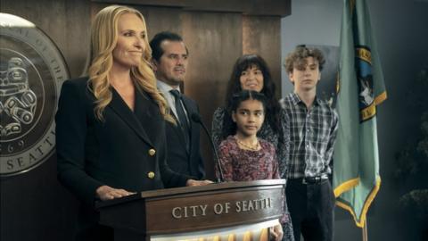 Toni Collette as Seattle Mayor Margot Cleary-Lopez, pictured with her husband, son and two daughters, in front of a City of Seattle podium