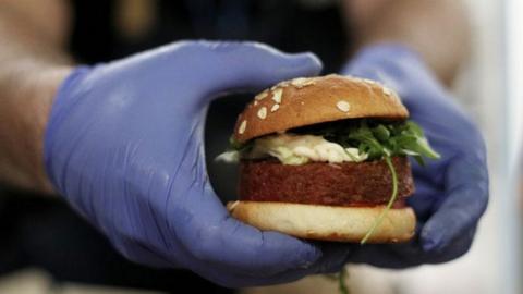 A cook prepares a 'Beyond Meat' burger, which is made of vegetable proteins.