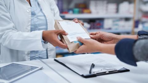 Closeup shot of an unrecognizable pharmacist assisting a customer in a chemist