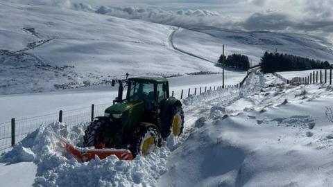 Tractor yn palu drwy'r eira trwchus yn Nrws y Nant, Y Bala