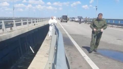 Russian Investigative Committee officers examining the damage on the Kerch Bridge