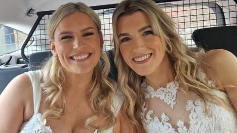 Two brides in the back of a police car