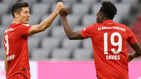 Robert Lewandowski (left) celebrates a Bayern Munich goal with team-mate Alphonso Davies