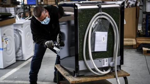 An employee inspects a washing-machine at the BSH electrical appliances