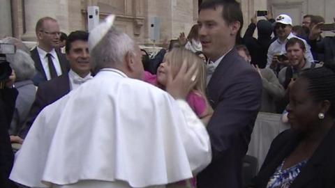 Girl removing Pope's hat