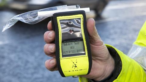 A Road Policing officer holds an operational breathalyser