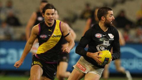 Kade Simpson of Carlton Blues carries the ball during an AFL match against Richmond Tigers at the MCG in August 2019