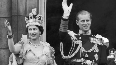 Queen Elizabeth II and the Duke Of Edinburgh wave to crowds from the balcony at Buckingham Palace in 1953