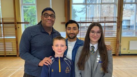 Paul Oakley Stovell and Nikhil Saboo with school pupils Jamie and Hanna
