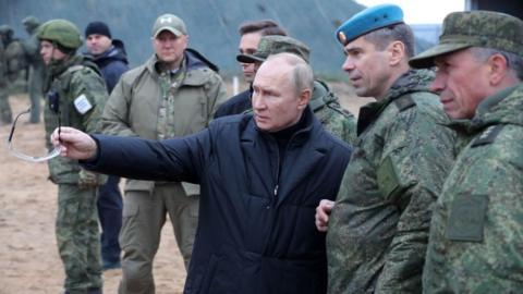 Russian President Vladimir Putin (C) meets soldiers during a visit at a military training centre of the Western Military District for mobilised reservists, outside the town of Ryazan
